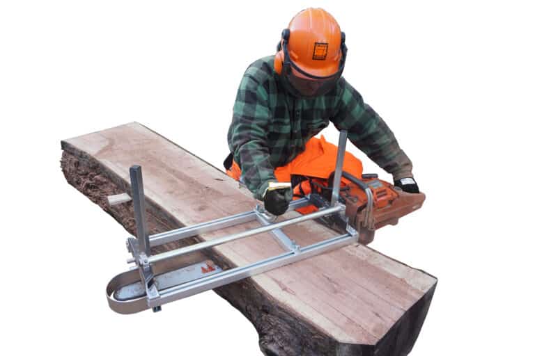 A man is working on a lumber using an Alaskan Mill.